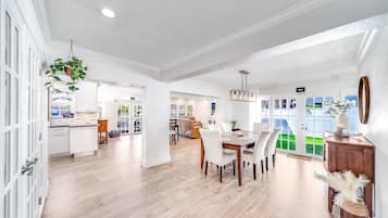 A spacious, well-lit interior with a dining area, kitchen, and open-plan layout.
