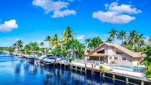 A waterfront property with a dock, boats, and a house with a pool. - Heated Pool! Waterfront+Kayak! Close 2 Beach! (Pompano Beach)