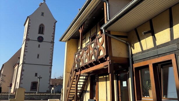 A building with a clock tower, a staircase, and a signboard. - Chez Anabel & Stéphane (Battenheim)