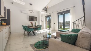 A modern living room with a sofa, a dining area with chairs, and a kitchen with a counter and cabinets. - Villa Dide moga ZadarVillas (Sveti Petar)