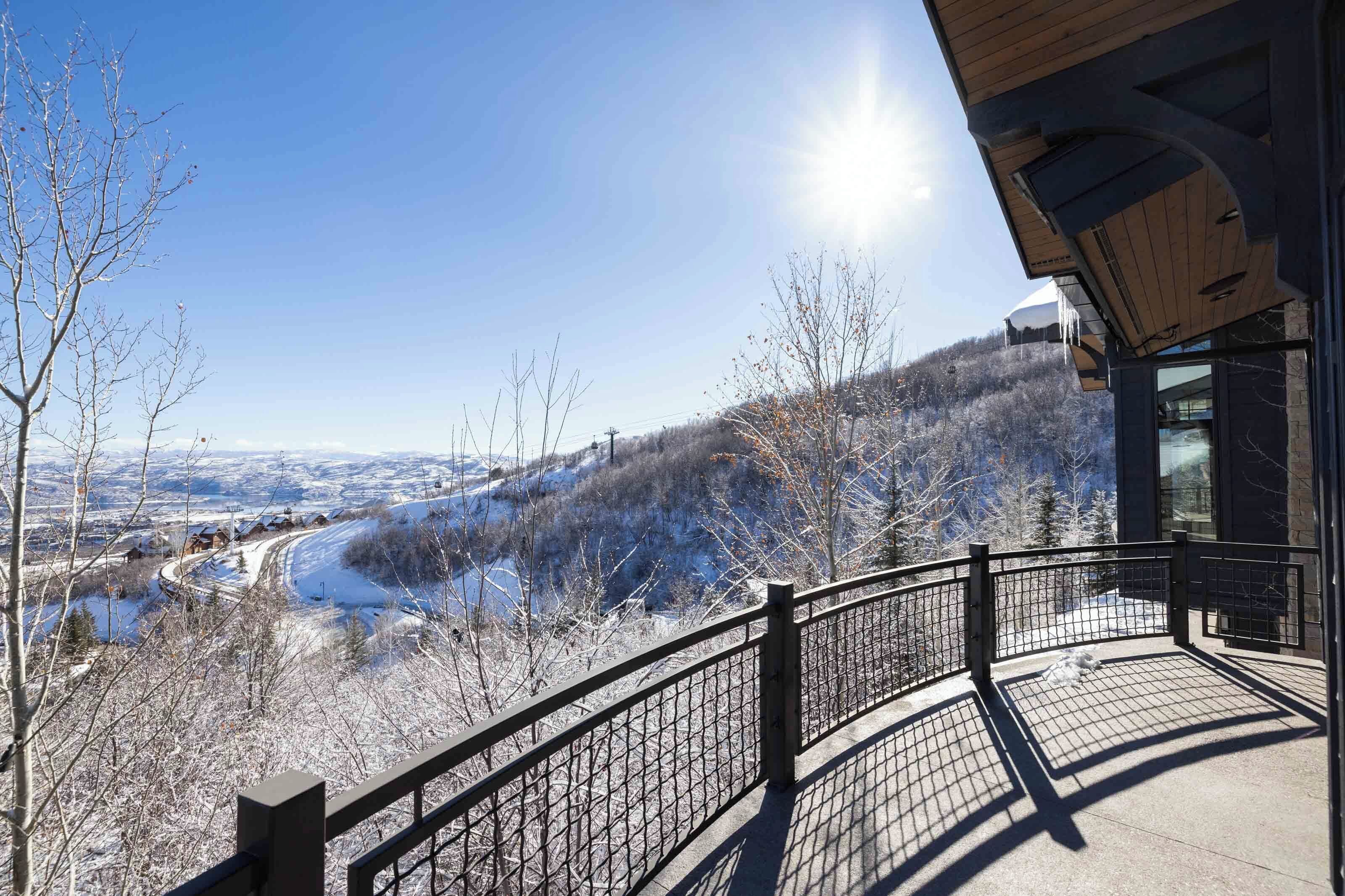 A balcony with a view of a snow-covered landscape and a river.