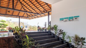 Una escalera adornada con plantas en macetas, un techo de paja y obras de arte en la pared.