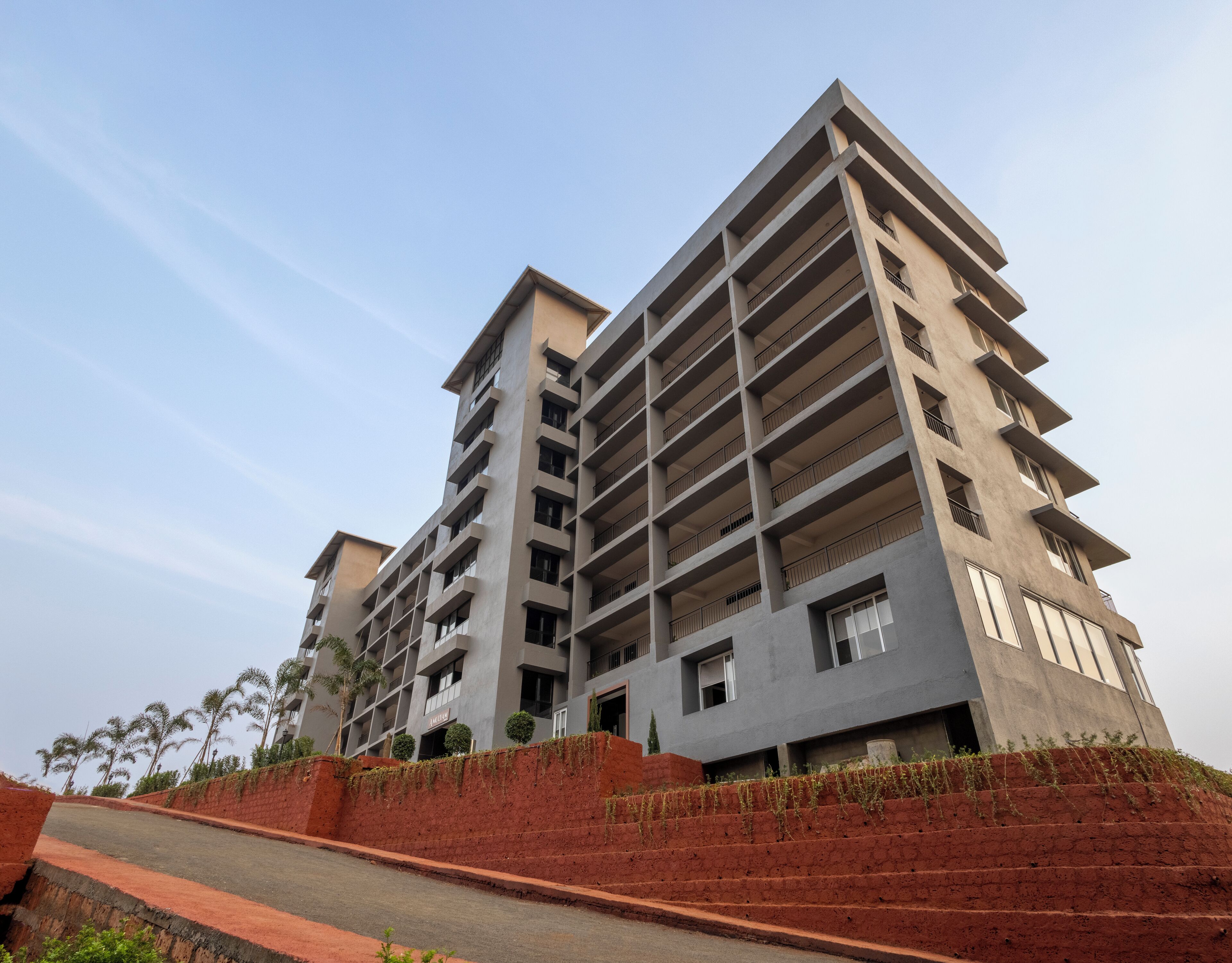 A multi-story residential building with balconies and a red brick facade.