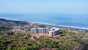 Un hotel costero con varias edificaciones, rodeado de vegetación y una playa.