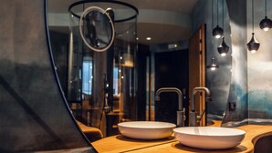 A modern bathroom with two sinks, a mirror, and pendant lights. - Loom Hotel (Bolzano)