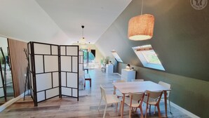 A modern interior with a dining area, a partition, and a view through a skylight. - LA GRANGE AU CORPS (Gussignies)