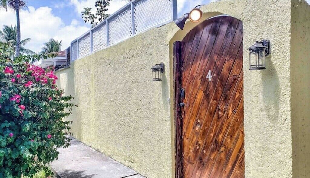 A wooden door with the number 4, a textured wall, and a small light fixture.