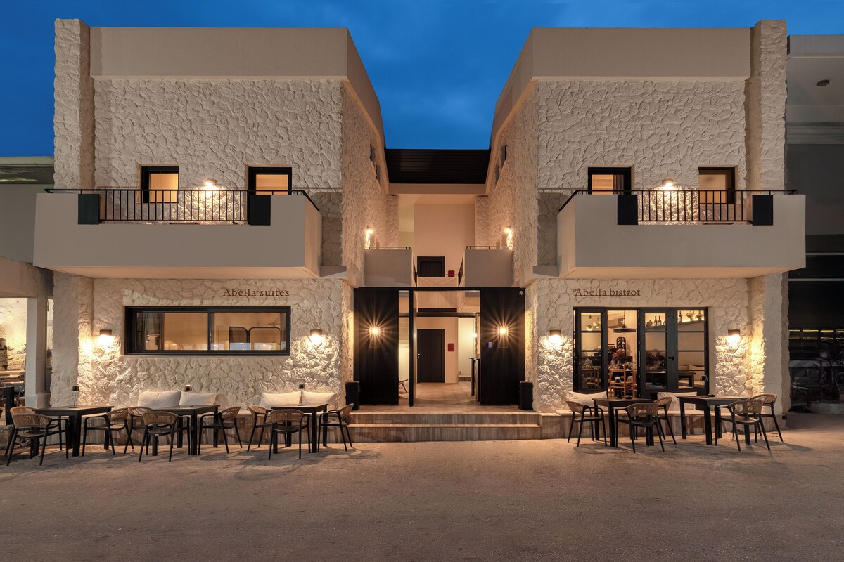 A two-story building with a stone facade, outdoor seating area, and a visible entrance.