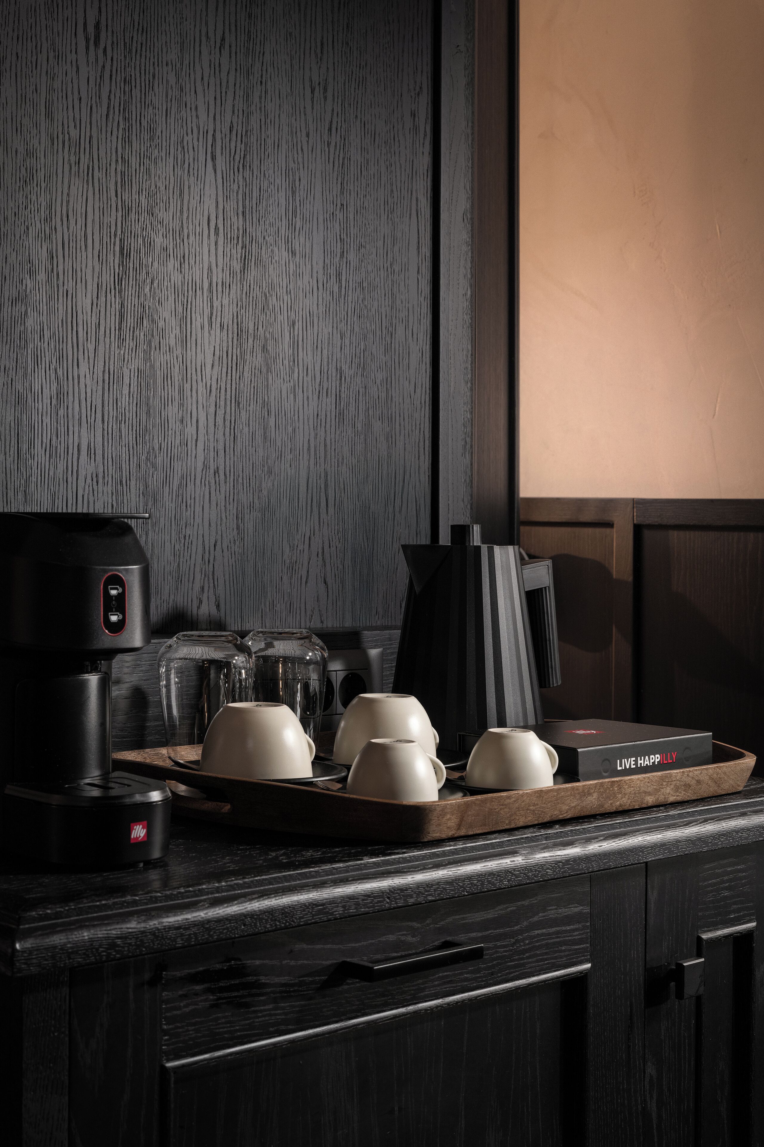Un comptoir de cuisine avec une machine à café, un plateau avec des tasses et une boîte sur laquelle est écrit : « Vivez heureux ».