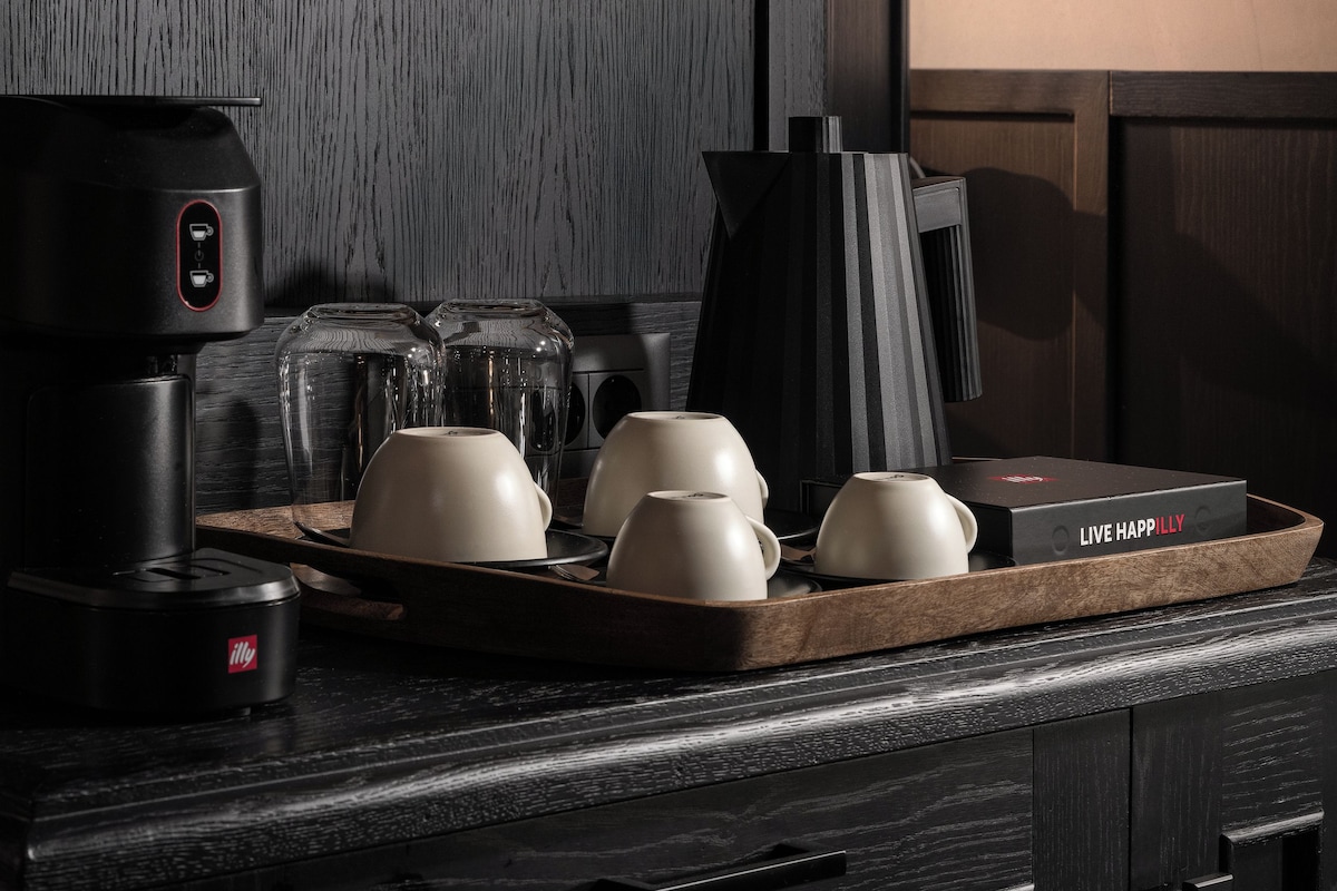 A kitchen counter with a coffee maker, a tray with cups, and a box labeled "LIVE HAPPILY".