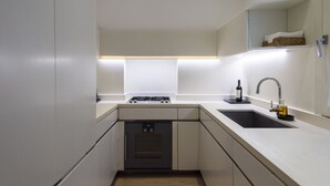 A modern kitchen with a built-in oven, a gas stove, a sink, and a countertop.
