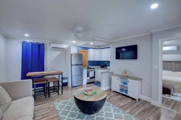 Um apartamento moderno com sala de estar, sala de jantar, cozinha e um quarto.