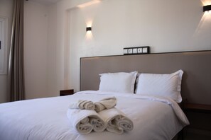 Habitación triple familiar, para no fumadores, vista a la ciudad | Escritorio, espacio para trabajar con laptop y cortinas blackout 