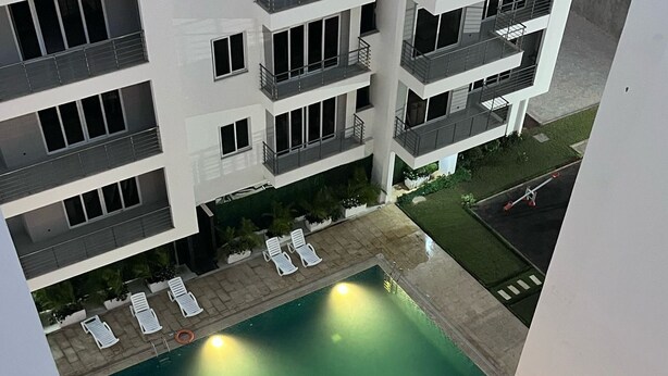 Una piscina en la azotea con varias sillas de descanso y una zona de piscina pequeña.