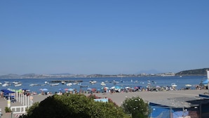 A coastal area with boats, umbrellas, and people on the beach. - La Finestra Sul Mare (Ischia)