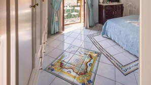 A bedroom with a bed, a dresser, a mirror, and a chandelier. - La Finestra Sul Mare (Ischia)