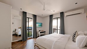 Hotellihuone, jossa on suuri sänky, työpöytä ja näkymä parvekkeelle.