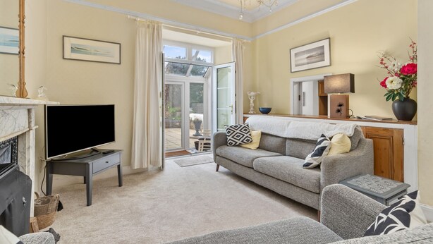 A living room with a television, sofa, and fireplace.