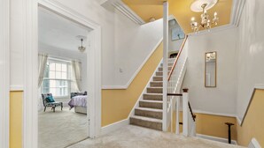 A staircase with a beige carpet leading to a room with a white door.
