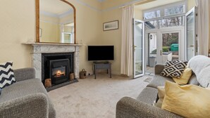 A living room with a fireplace, a television, and a sofa.