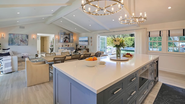 A spacious kitchen with a large island, modern appliances, and a chandelier.