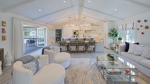 A spacious living area with a large dining table, a sofa, and a coffee table.