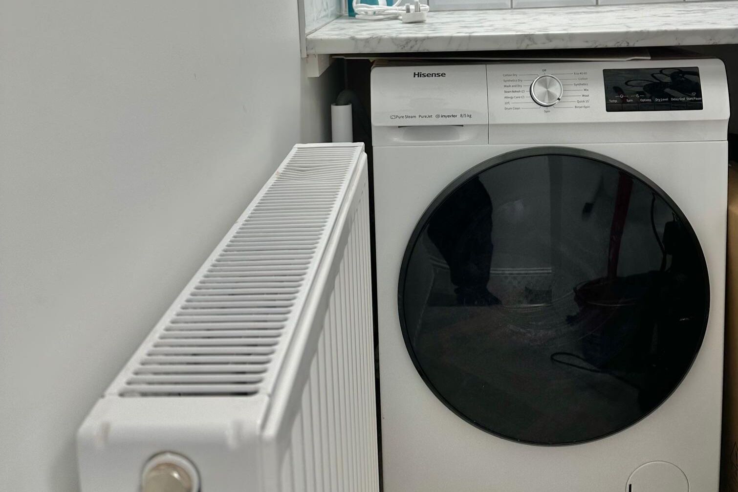 A Hisense PureSteam PureJet Inverter dryer with a control panel and a vent.