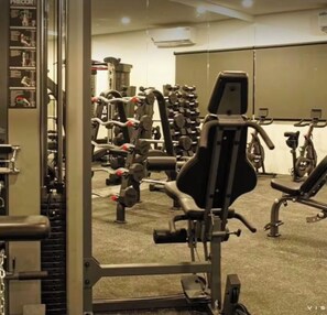 A gym with various exercise equipment, including treadmills, stationary bikes, and weight machines.