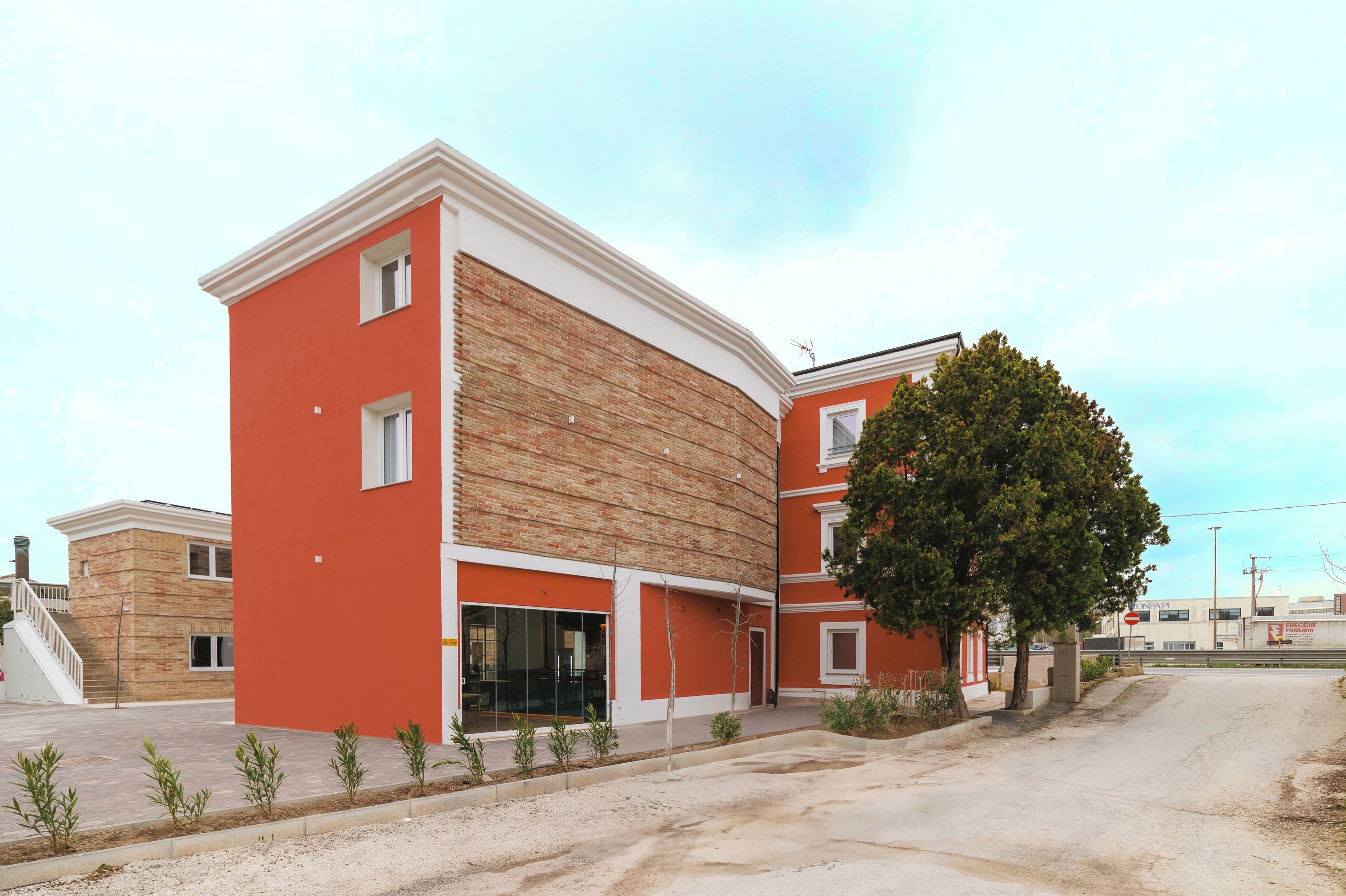 A multi-story building with a red facade and a brick section.