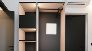 Une chambre moderne dotée d’une armoire intégrée, d’un lit et d’un appareil de climatisation.