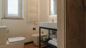 Un baño moderno con inodoro, bidé y lavamanos.
