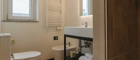 Un baño moderno con inodoro, bidé y lavamanos.