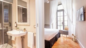 A bathroom with a sink, mirror, and shower. - Hotel Parrasio (Rome)