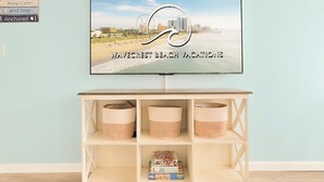 A television displaying a beach vacation advertisement with a Ferris wheel and beach scene.