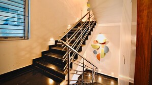 Eine Treppe mit Metallgeländern und Handlauf, die zu einer oberen Etage führt.
