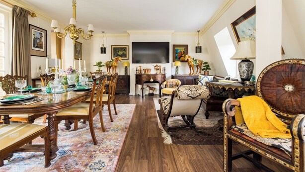 A spacious living room with a large wooden dining table, comfortable seating, and a flat-screen TV mounted on the wall. - Mayfair 3-bed 6-guest W/patio & ac Berkeley Square (London)