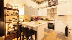 A modern kitchen with white cabinets, a central island, and a decorative ceiling. - Large 4-bed 8-guests W/patio 1841 House Paddington (London)