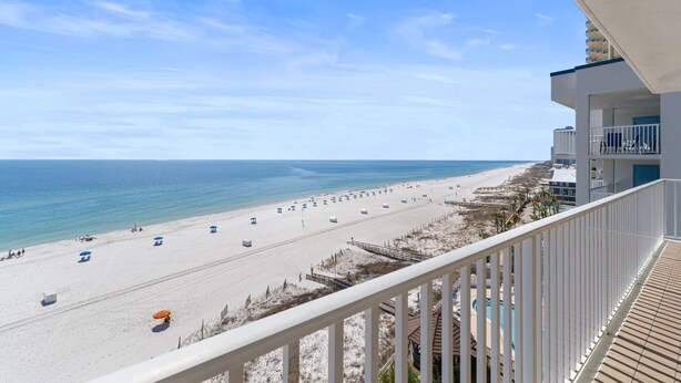 A beach view from a balcony with a clear sky, sandy beach, and ocean. - 🌴🌊Romar Place 806: Beautiful Corner Unit | Beachfront (Orange Beach)