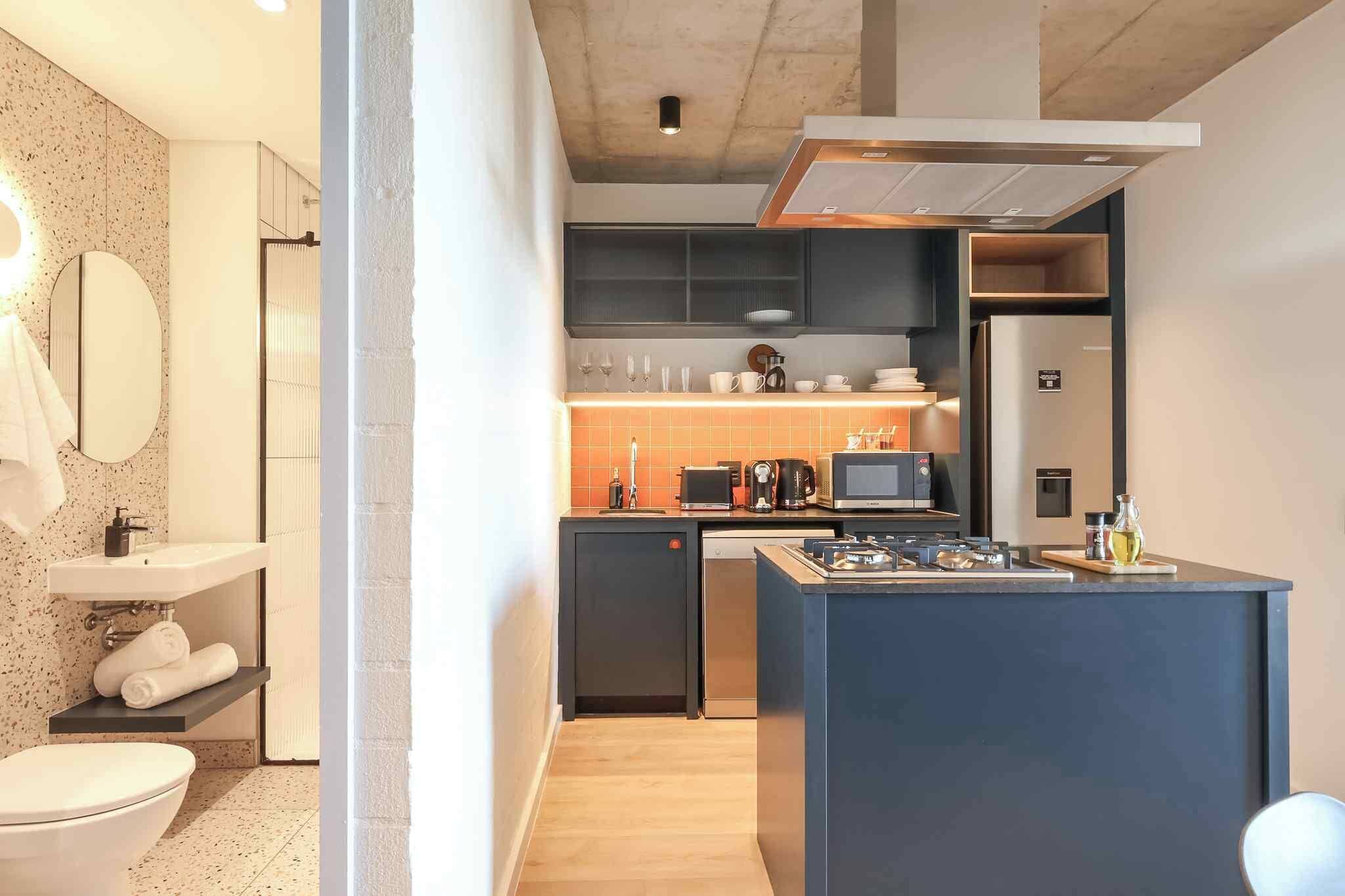 A compact kitchen with a microwave, coffee maker, and a small island with a sink.