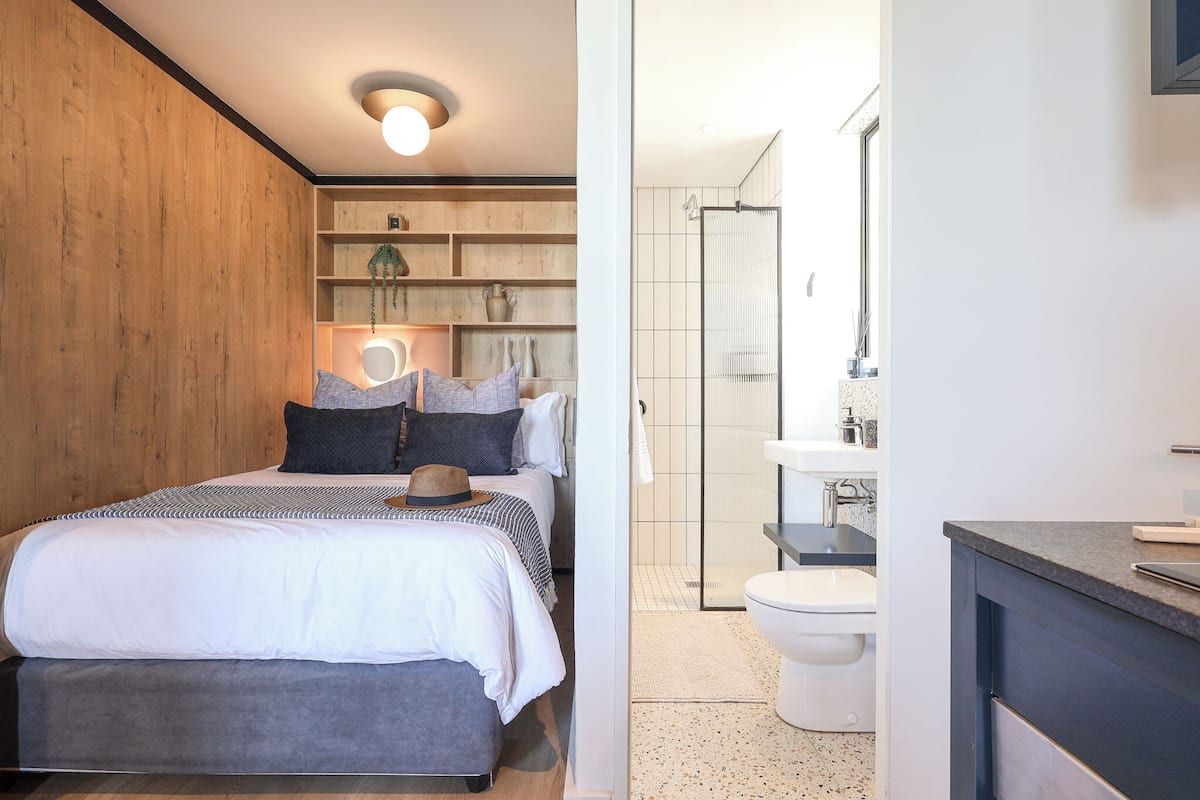 A bedroom with a bed, bedside tables, and a nightstand.