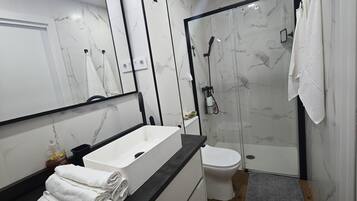 Een haardroger, handdoeken, zeep, toiletpapier