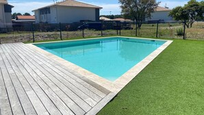 A rectangular swimming pool with a wooden deck and artificial grass surrounding it. - E03, welcoming 3* duplex near ocean & forest (Mimizan)