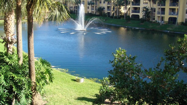 A water fountain in a courtyard with palm trees and a building in the background. - Lake Front 3-bedroom condo walk to Nextera and beach in Juno Beach (JUNO BEACH)