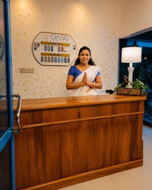 Un comptoir d’accueil avec une pancarte indiquant « Clé pour les clients » et « Clé de l’hôtel », une pancarte « Accueil » et une plante sur le comptoir.