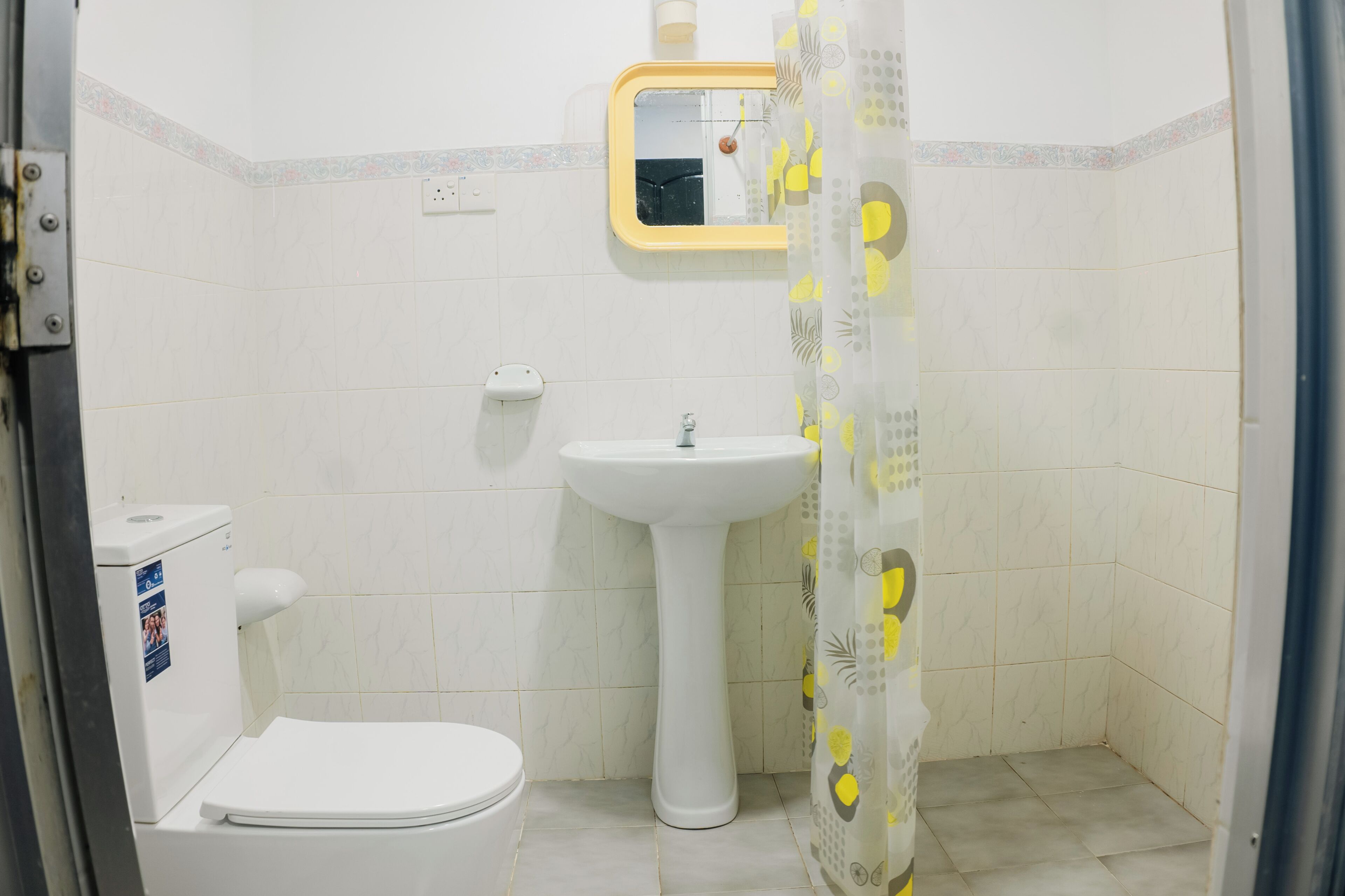 Un baño pequeño con inodoro, lavamanos y cortina de ducha.