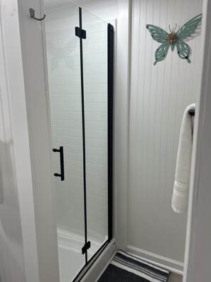 Een douche, handdoeken, zeep, shampoo
