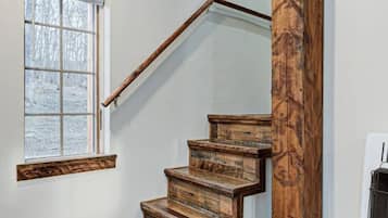 A wooden staircase with a glass balustrade leading to a landing.