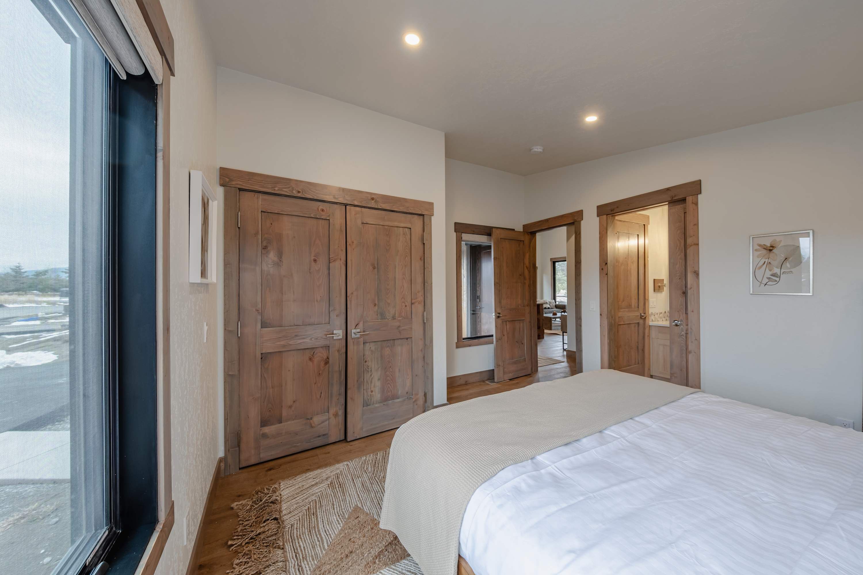 Ein Schlafzimmer mit einem großen Bett, einem Holzschrank und einem Fenster.