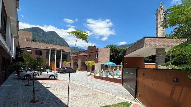 Un patio con un camino pavimentado, un pequeño césped y un edificio de ladrillo con una estatua en la parte superior.