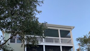 Un edificio de dos pisos con un balcón en el nivel superior y una escalera que conduce a ese nivel.